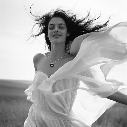 Young woman in a flowing white dress wearing a shungite EMF protection pendant outdoors