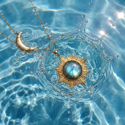 Sunburst labradorite pendant and crescent moon necklace creating splash in clear blue water