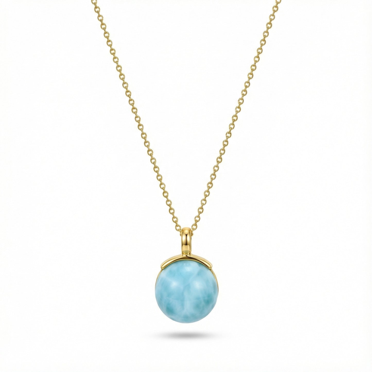 Gold chain necklace with round larimar pendant featuring ocean-like blue stone