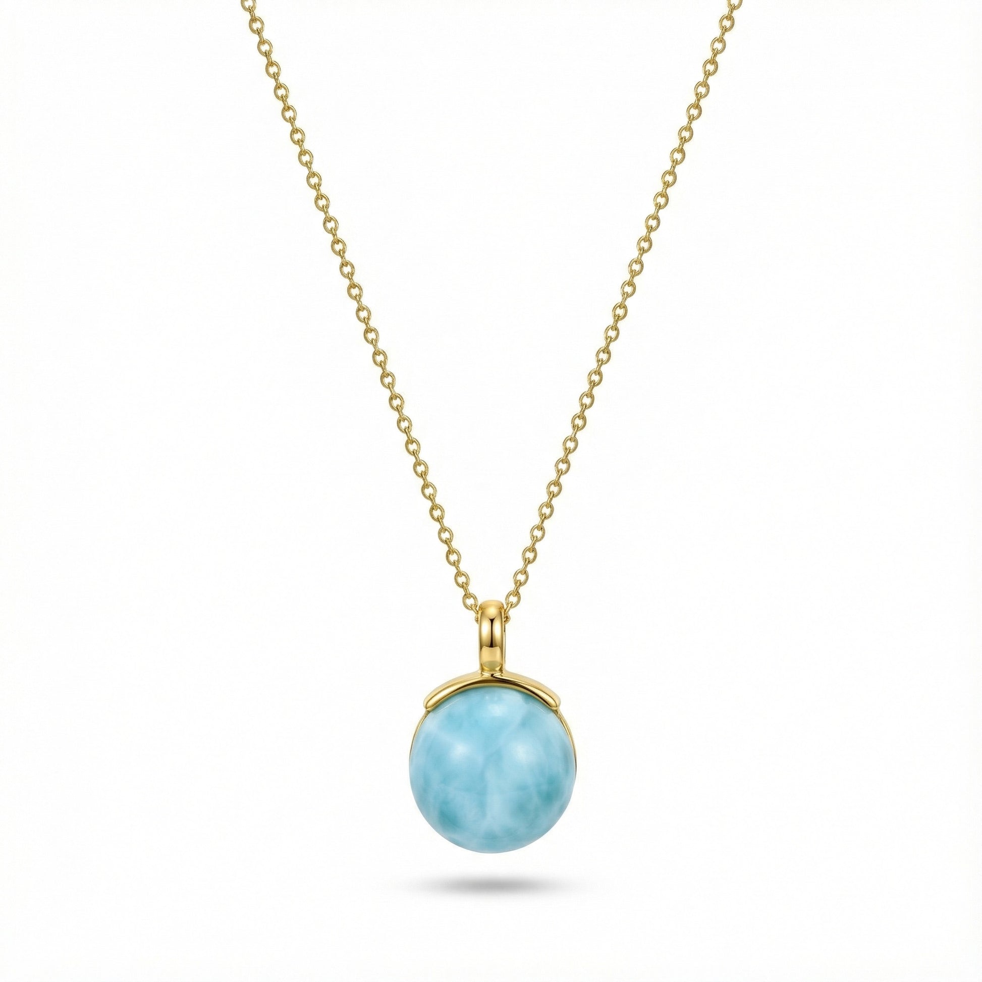 Gold chain necklace with round larimar pendant featuring ocean-like blue stone
