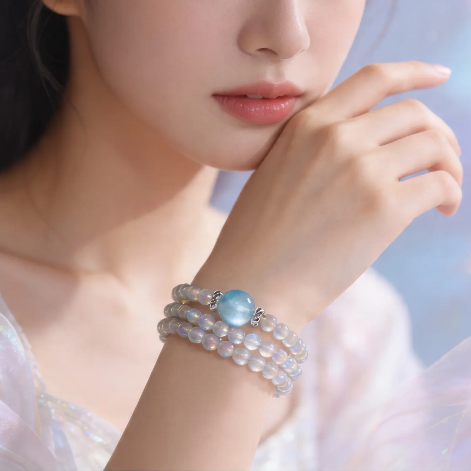 Woman wearing a bracelet with a blue gemstone against a soft, blurred background